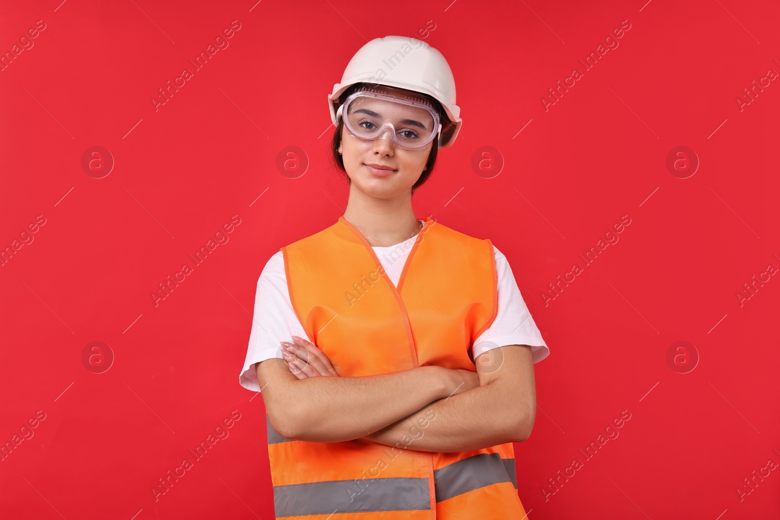 Photo of Girl with safety equipment on red background. Work for teenagers