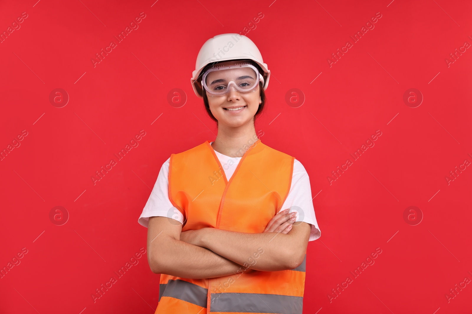 Photo of Girl with safety equipment on red background. Work for teenagers