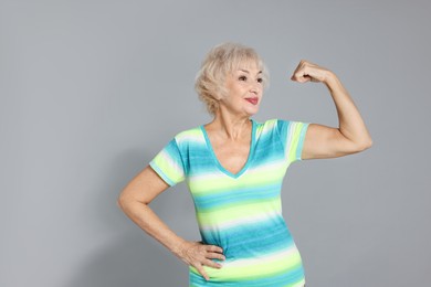 Photo of Senior woman exercising on light grey background