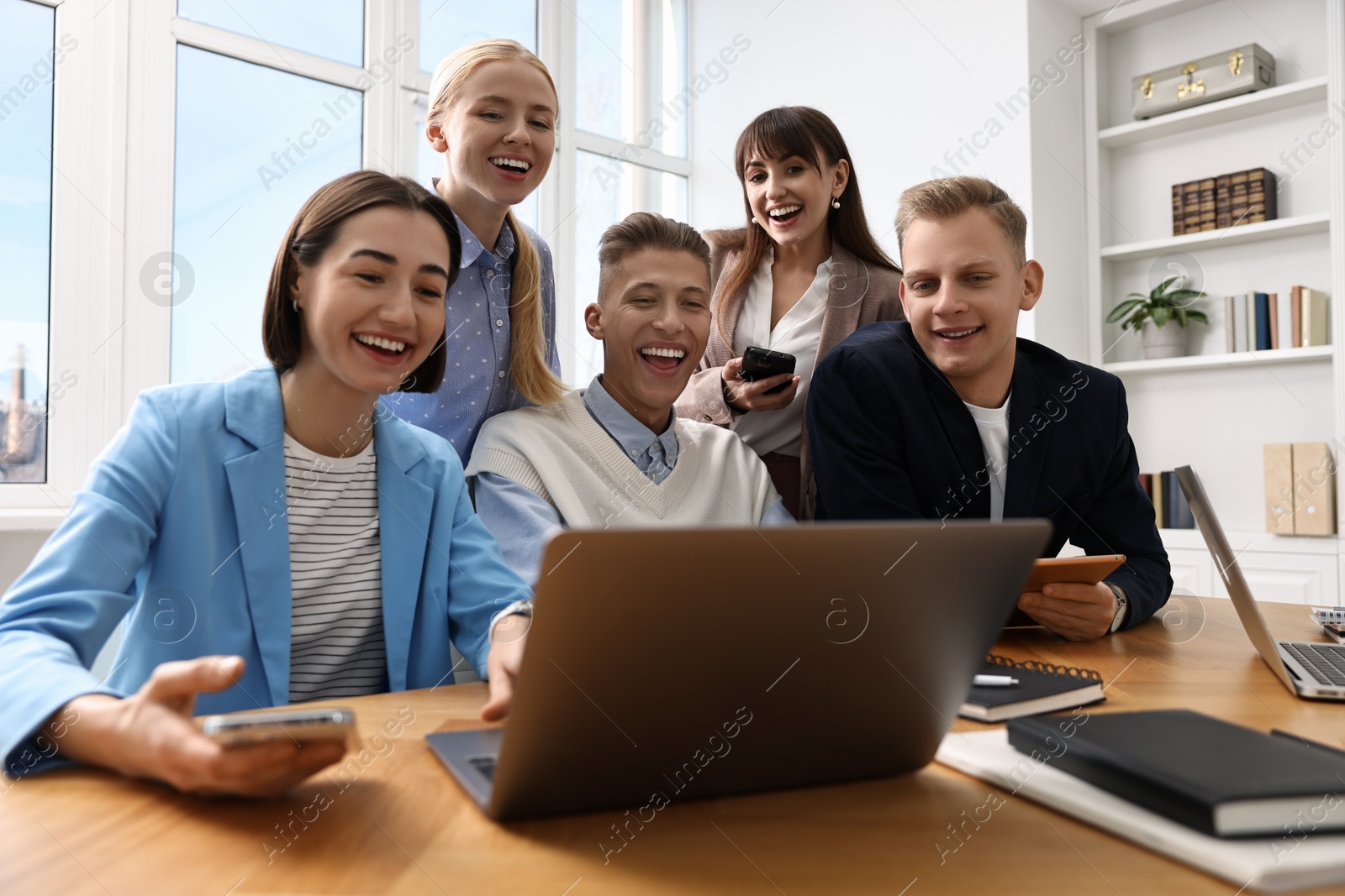 Photo of Group of people using different gadgets at wooden table in office. Modern technology