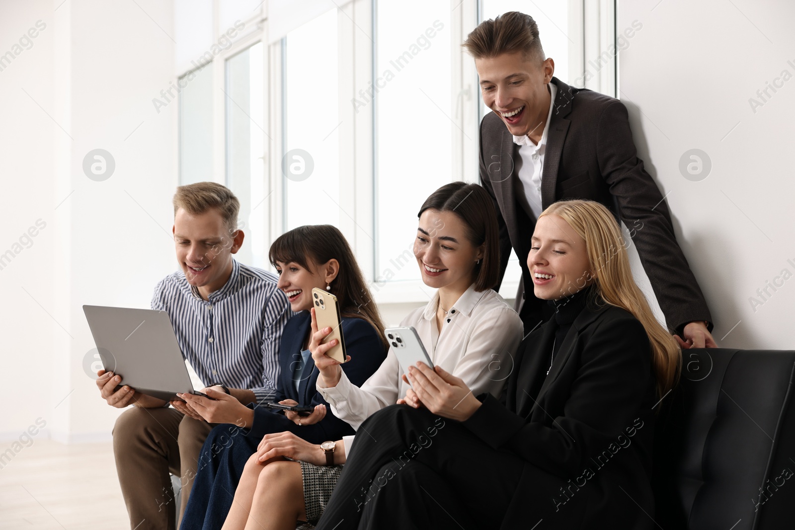 Photo of Group of people using different gadgets near window indoors. Modern technology