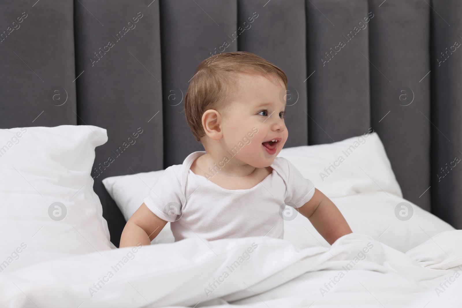 Photo of Funny little baby playing on bed at home