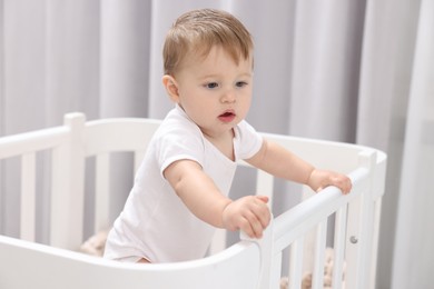 Photo of Cute little baby in crib at home