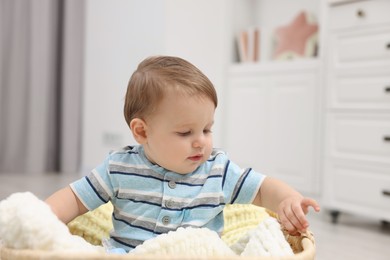 Photo of Cute baby boy in basket at home