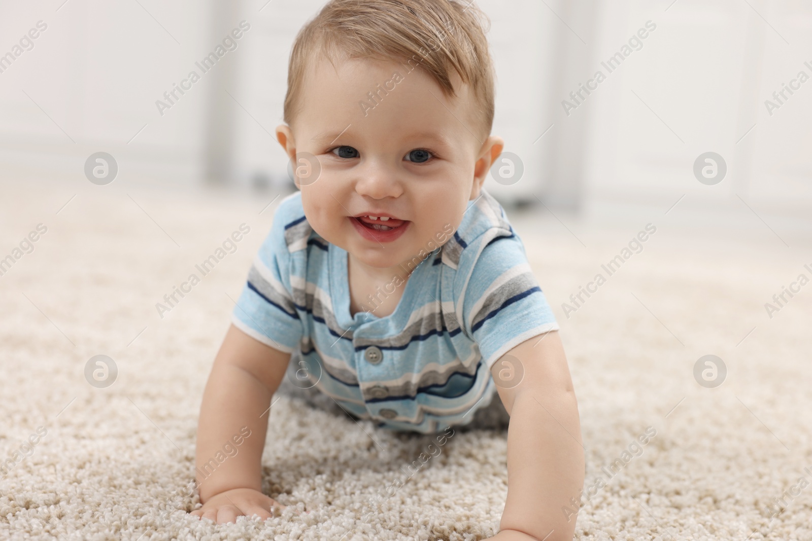 Photo of Adorable baby boy on floor at home