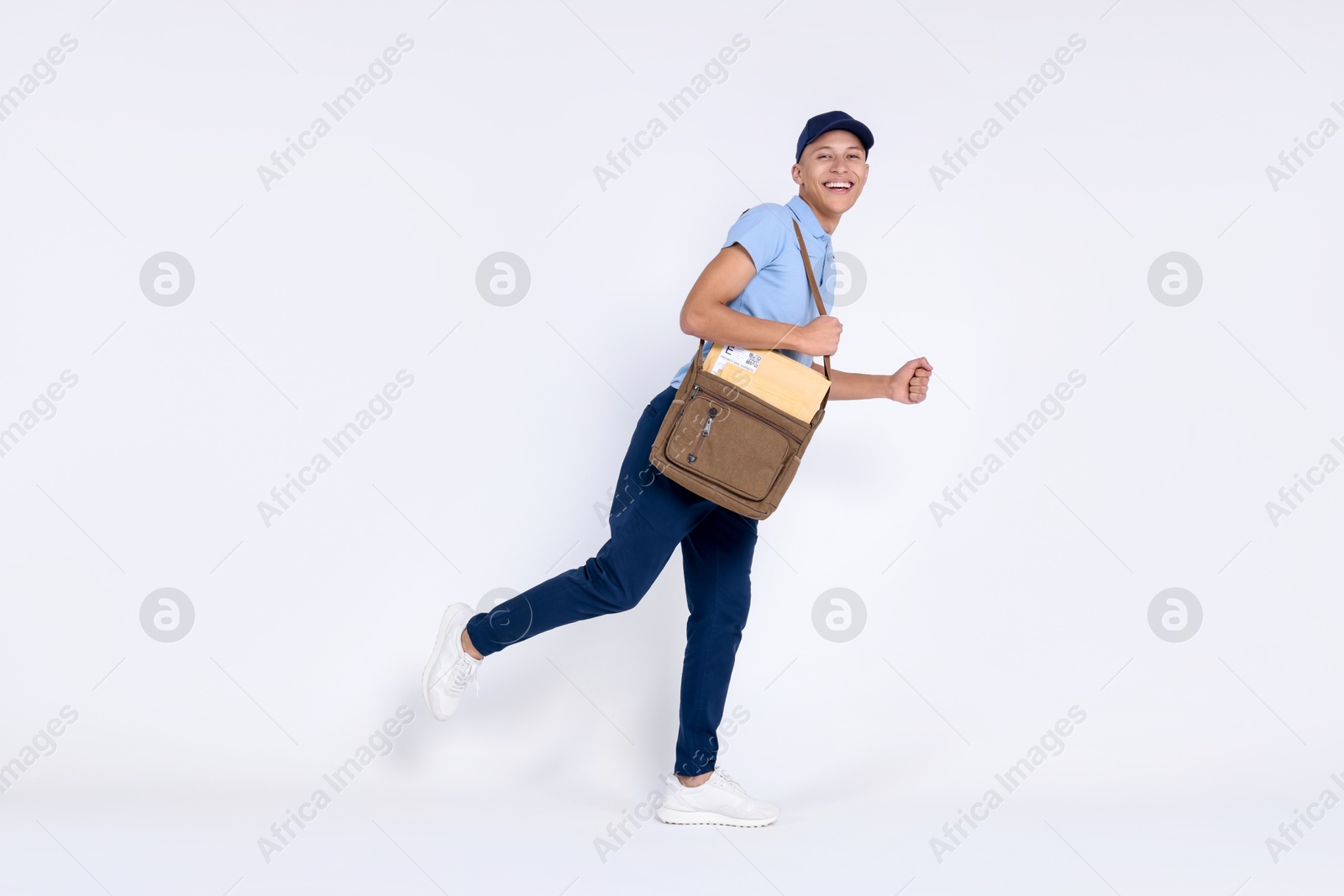 Photo of Happy postman with bag and envelopes on white background. Space for text