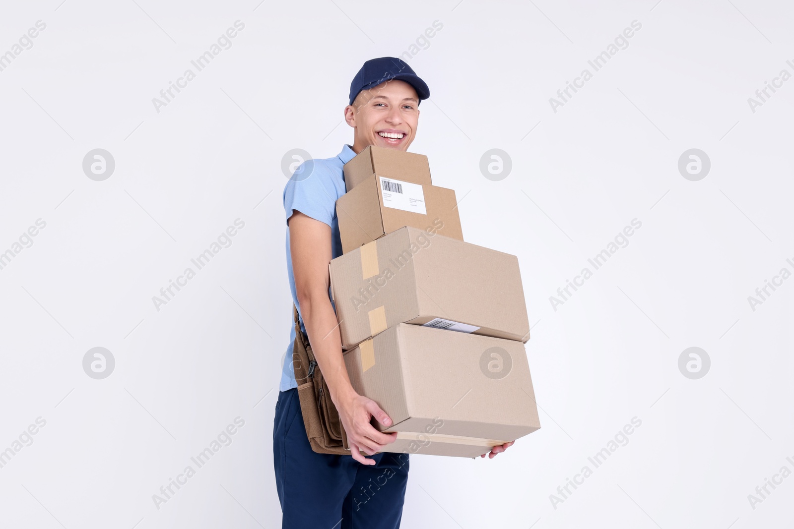 Photo of Happy postman with parcels on white background