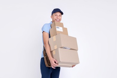 Photo of Happy postman with parcels on white background