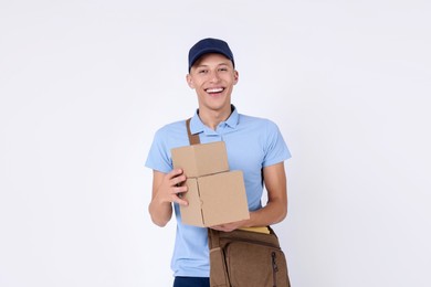 Photo of Happy postman with bag and parcels on white background