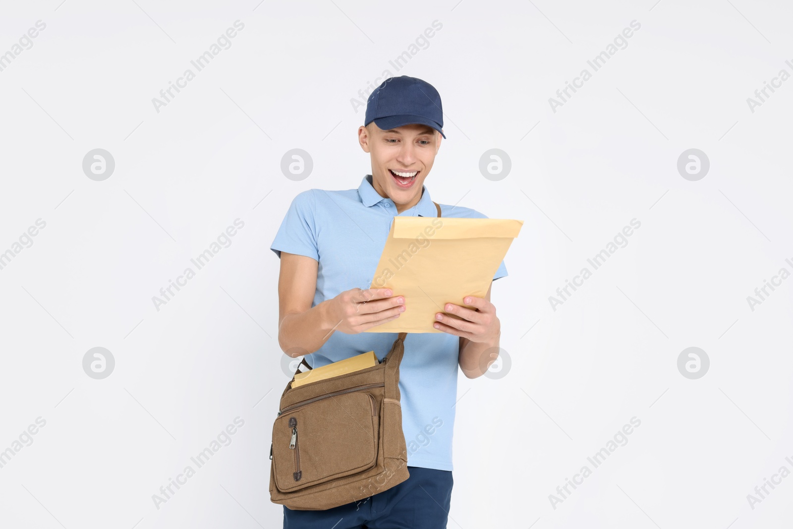 Photo of Happy postman with bag and envelope on white background