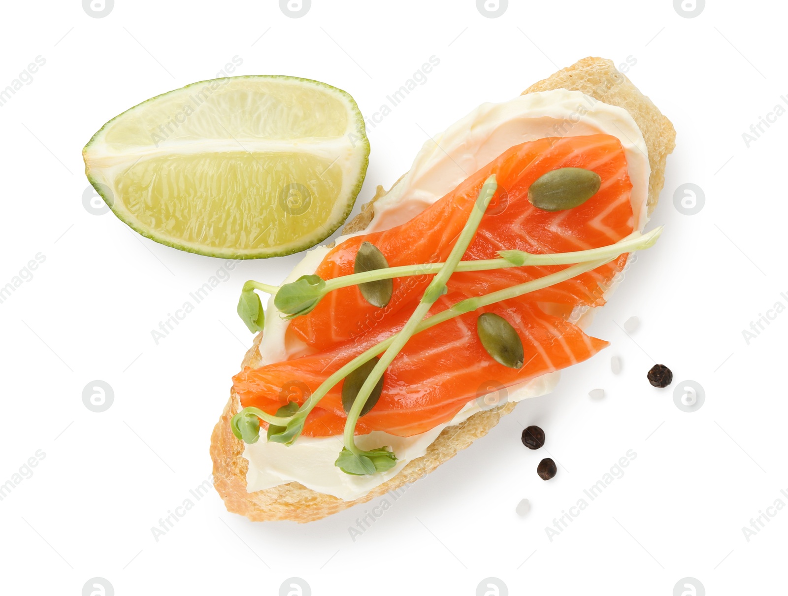 Photo of Delicious bruschetta with cream cheese, salmon and piece of lime isolated on white, top view