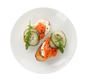 Photo of Delicious bruschette with cream cheese, salmon and cucumber isolated on white, top view