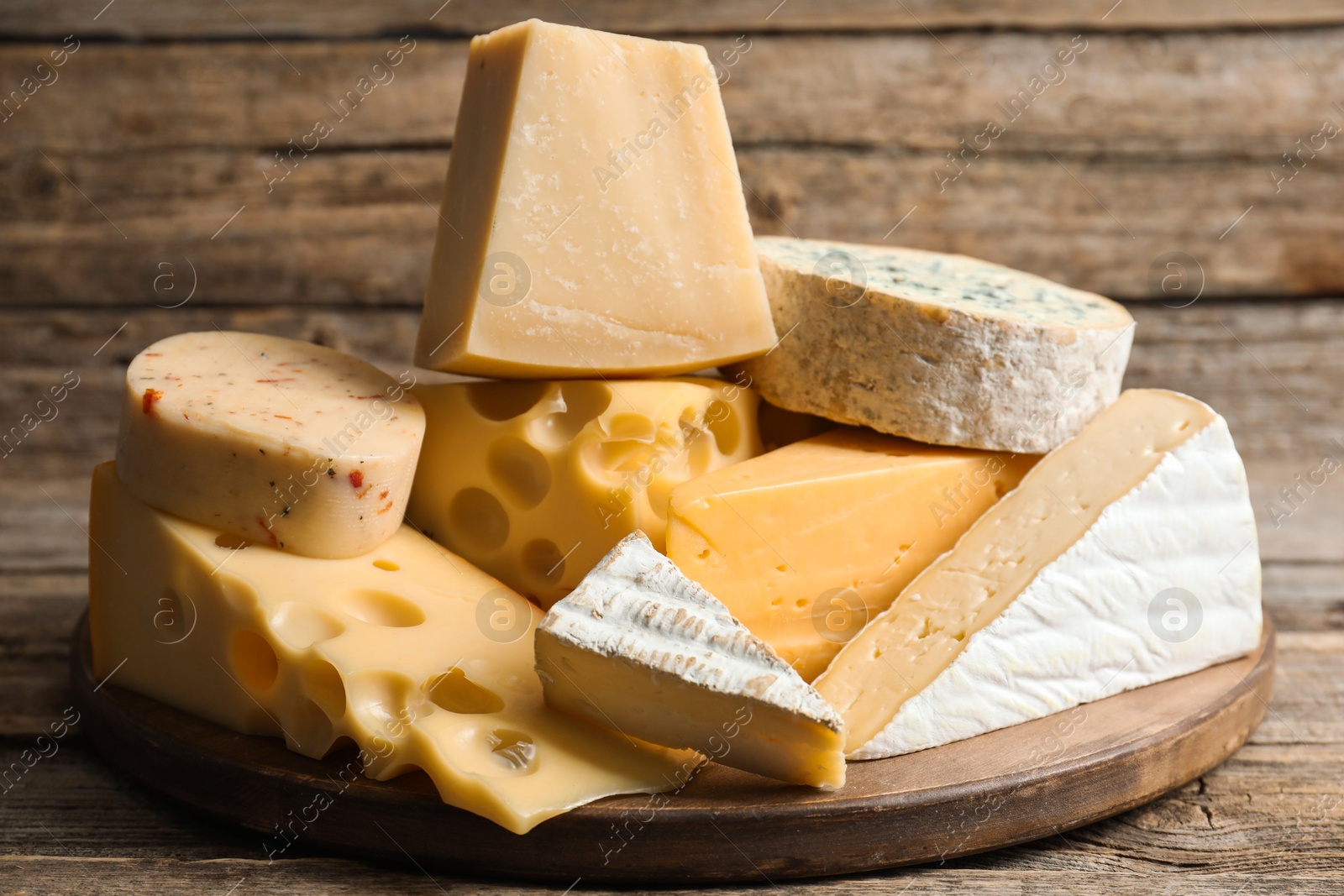 Photo of Different types of cheese on wooden table, closeup