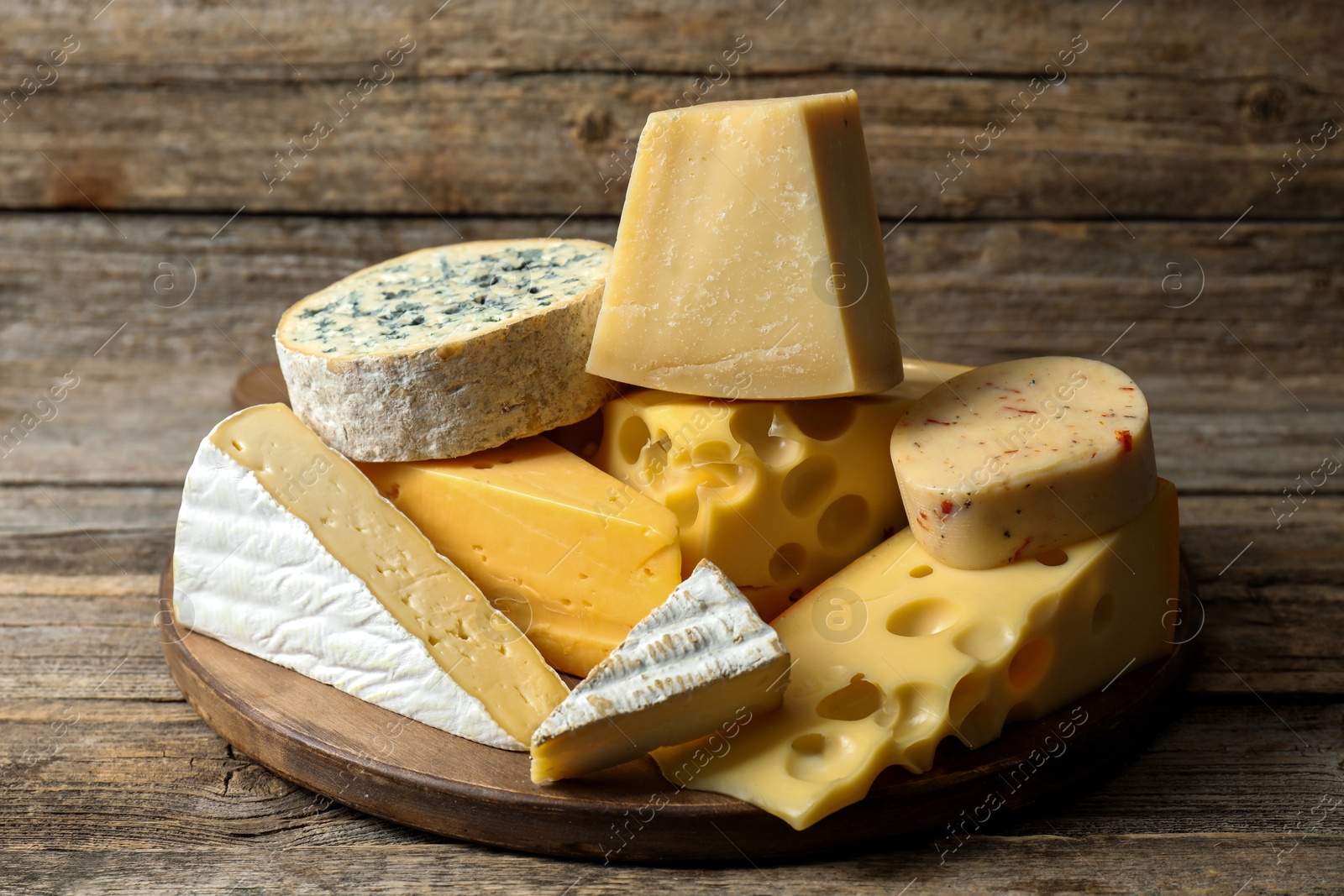 Photo of Different types of cheese on wooden table