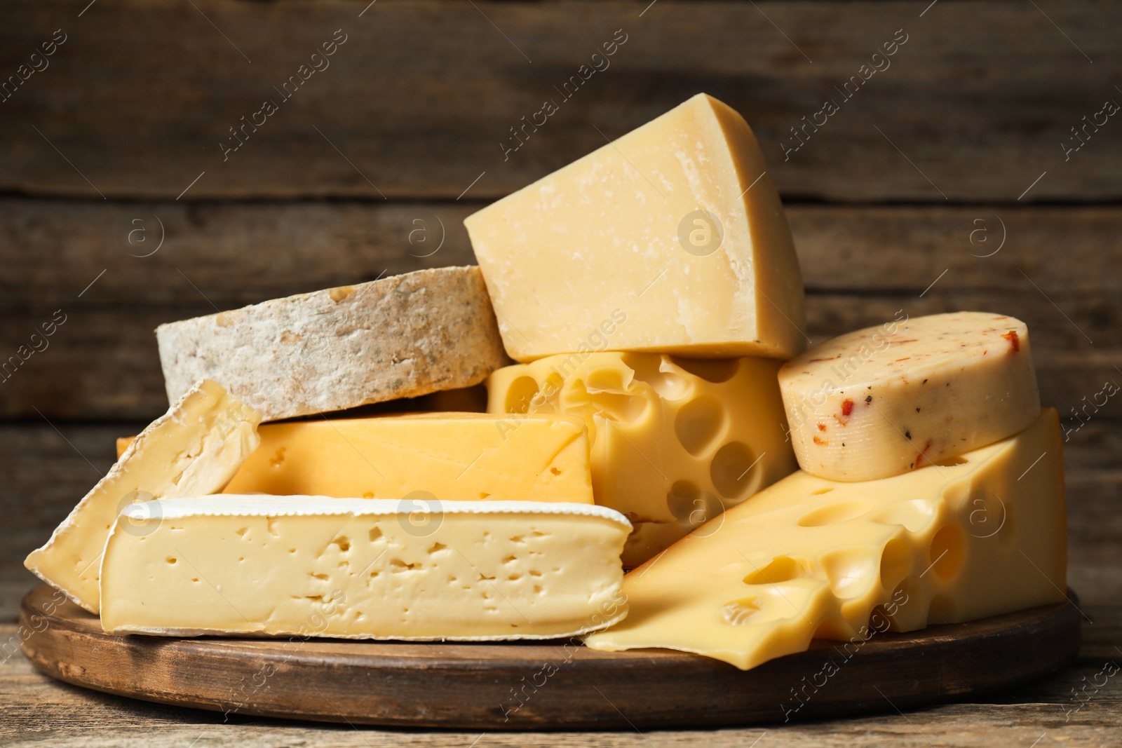 Photo of Different types of cheese on wooden table