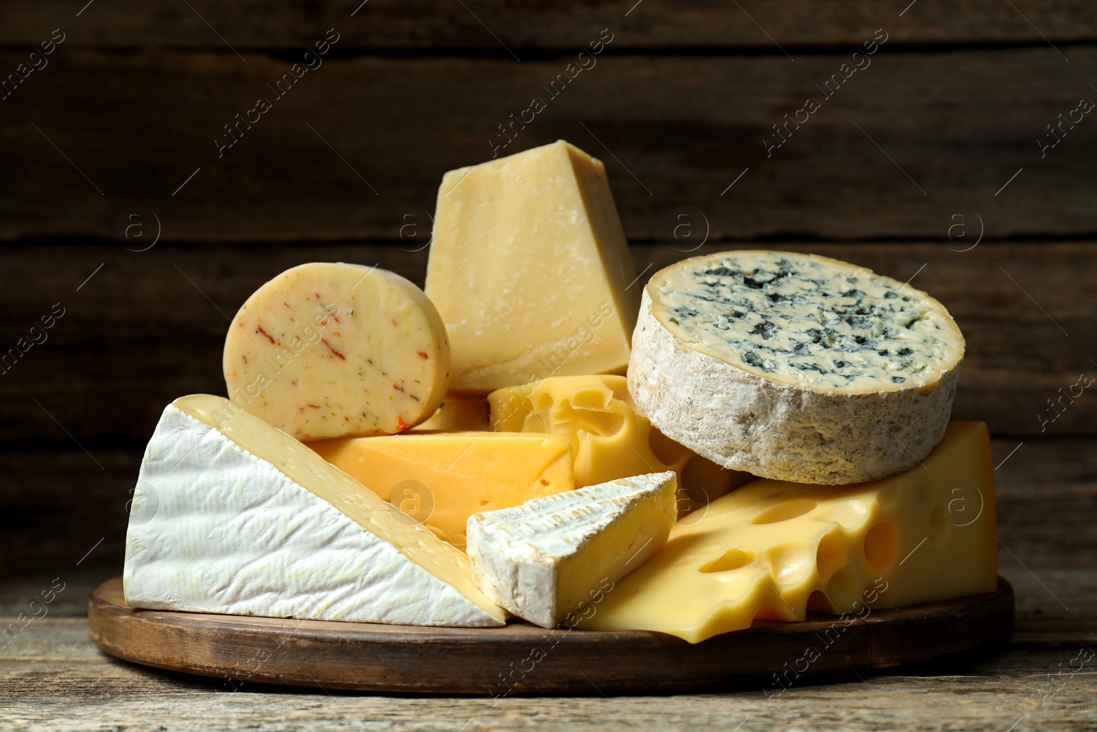 Photo of Different types of cheese on wooden table