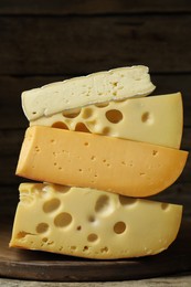 Photo of Stacked different types of cheese on table