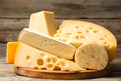 Photo of Different types of cheese on wooden table, closeup