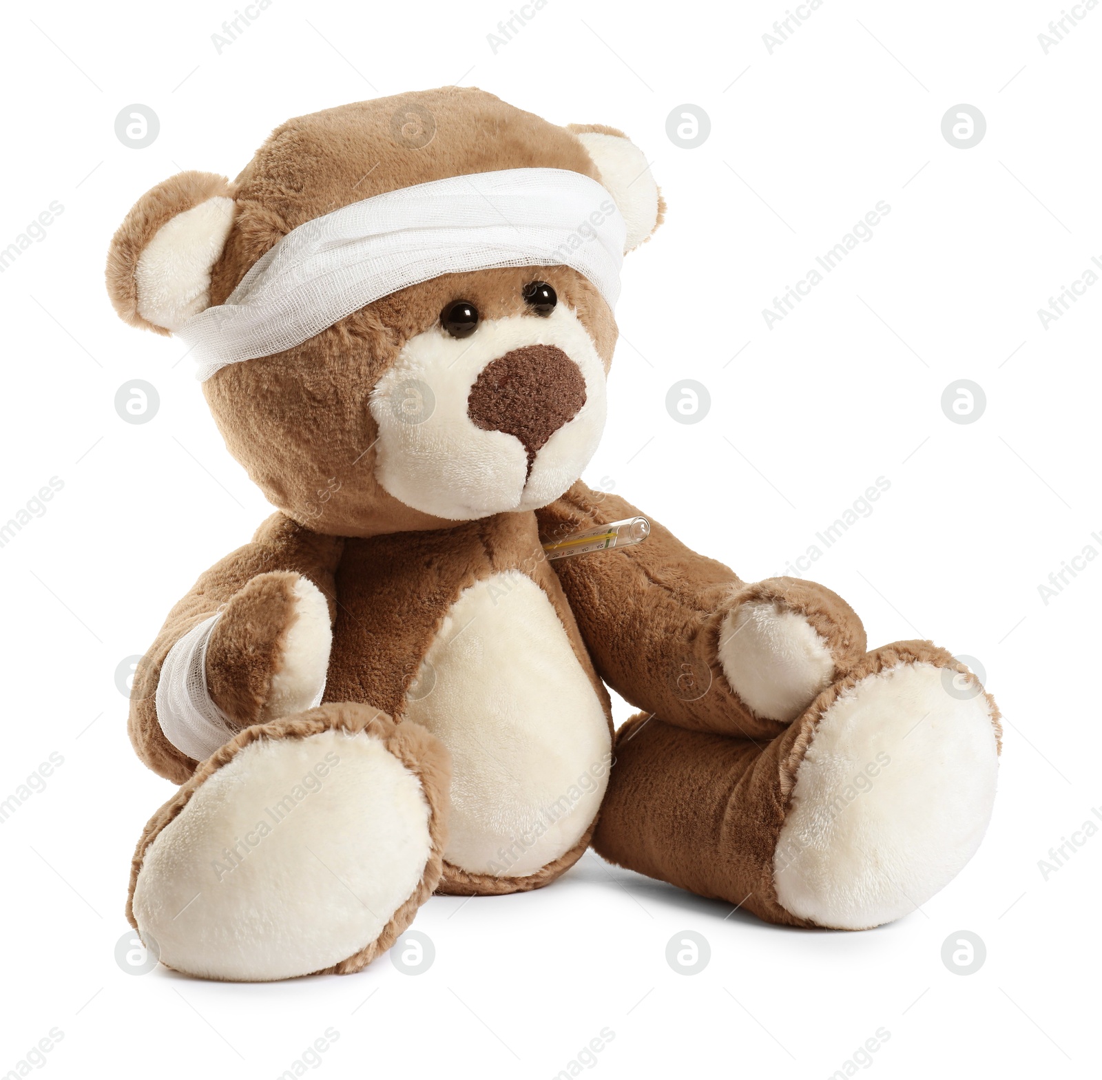 Photo of Teddy bear with bandages and thermometer isolated on white