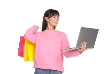 Photo of Internet shopping. Smiling woman with laptop and colorful bags on white background