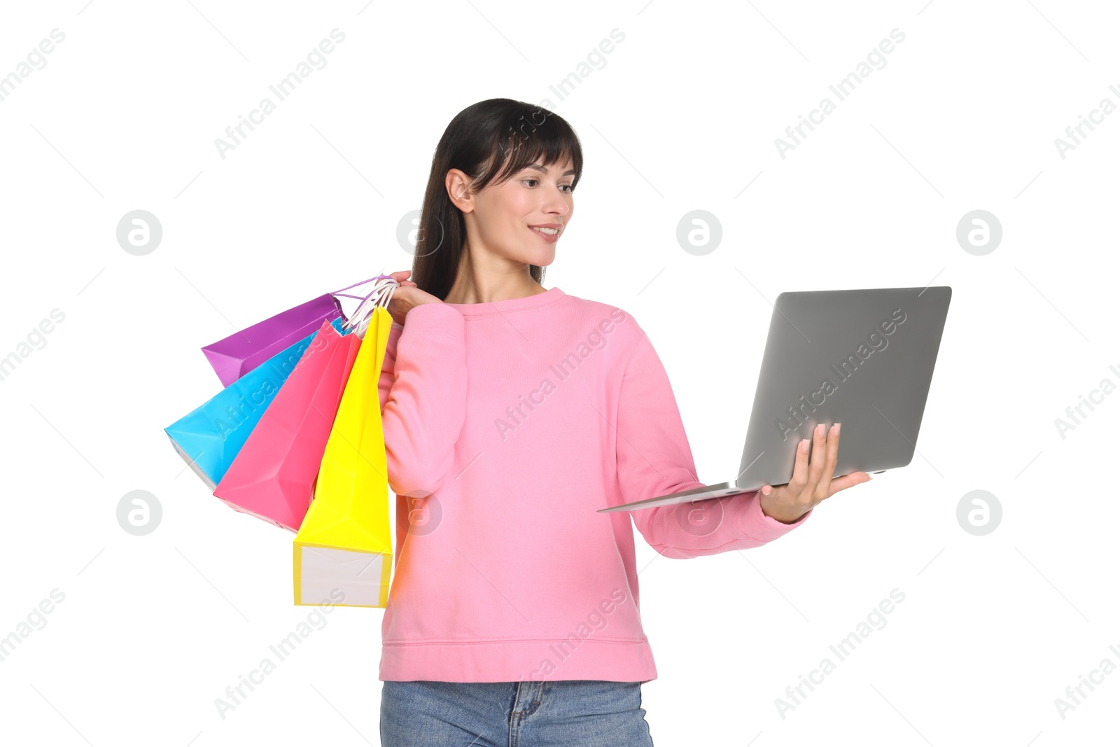 Photo of Internet shopping. Smiling woman with laptop and colorful bags on white background