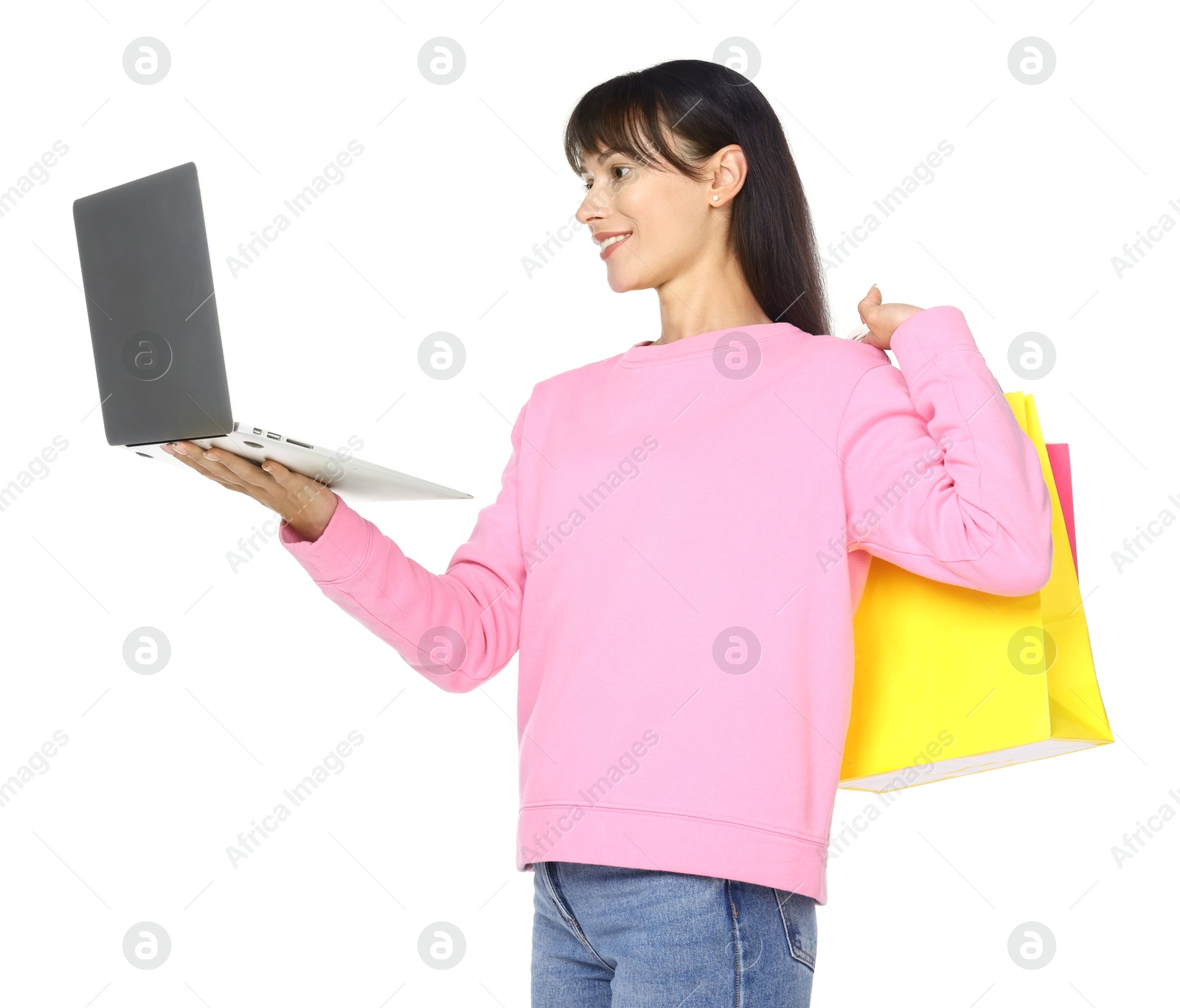 Photo of Internet shopping. Smiling woman with laptop and colorful bags on white background