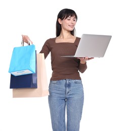 Photo of Internet shopping. Happy woman with laptop and colorful bags on white background