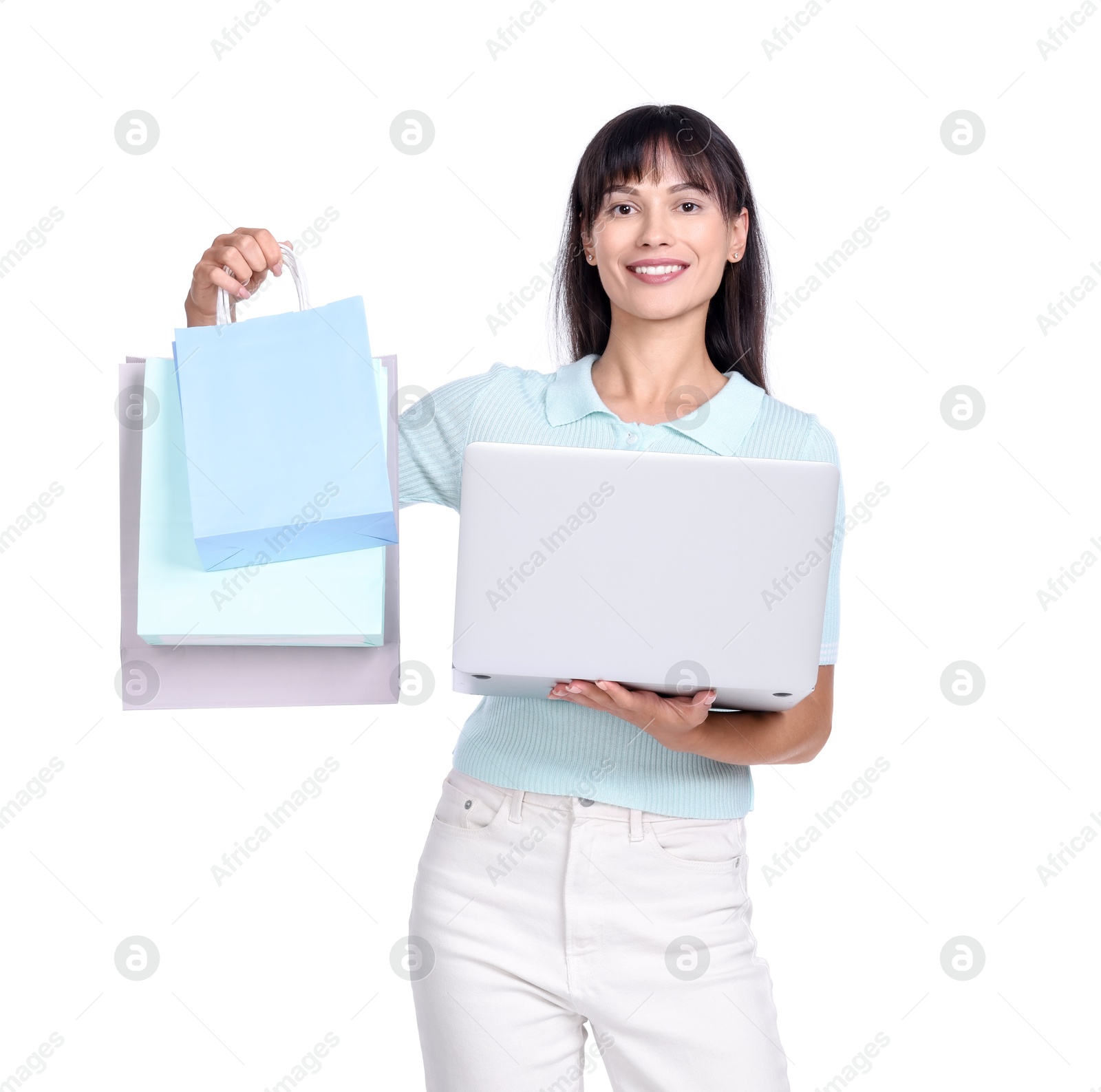 Photo of Internet shopping. Happy woman with laptop and colorful bags on white background