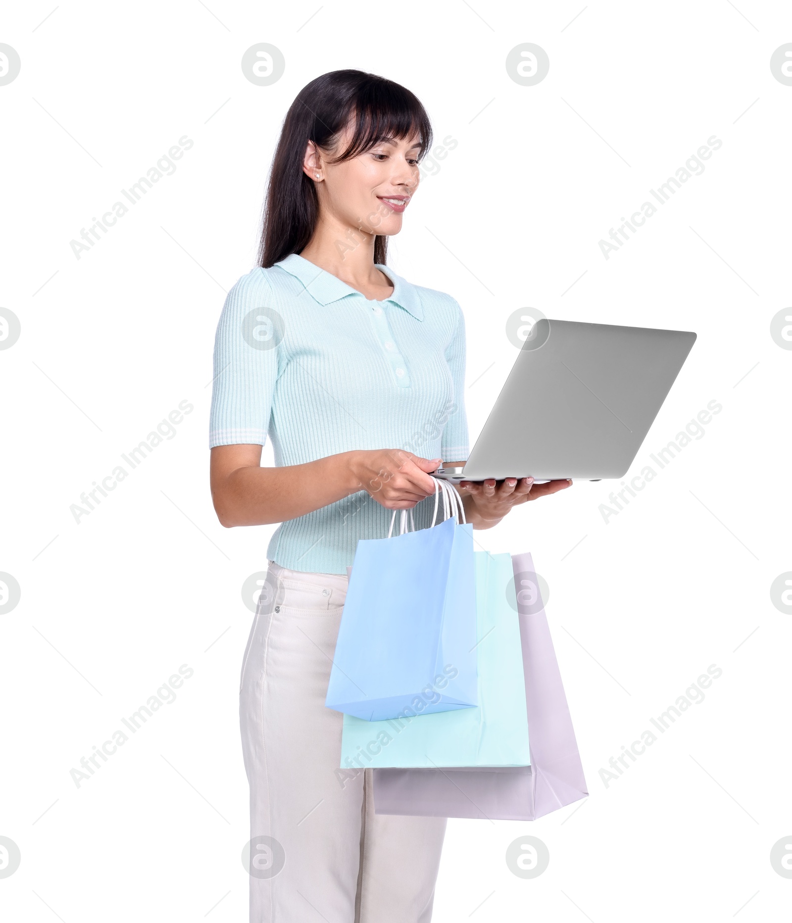 Photo of Internet shopping. Happy woman with laptop and colorful bags on white background