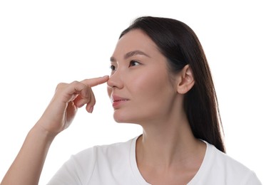 Photo of Young woman touching her nose on white background