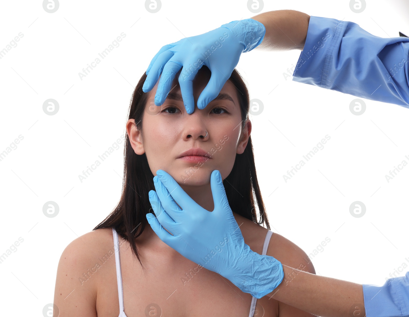 Photo of Doctor checking patient's nose before plastic surgery operation on white background, closeup