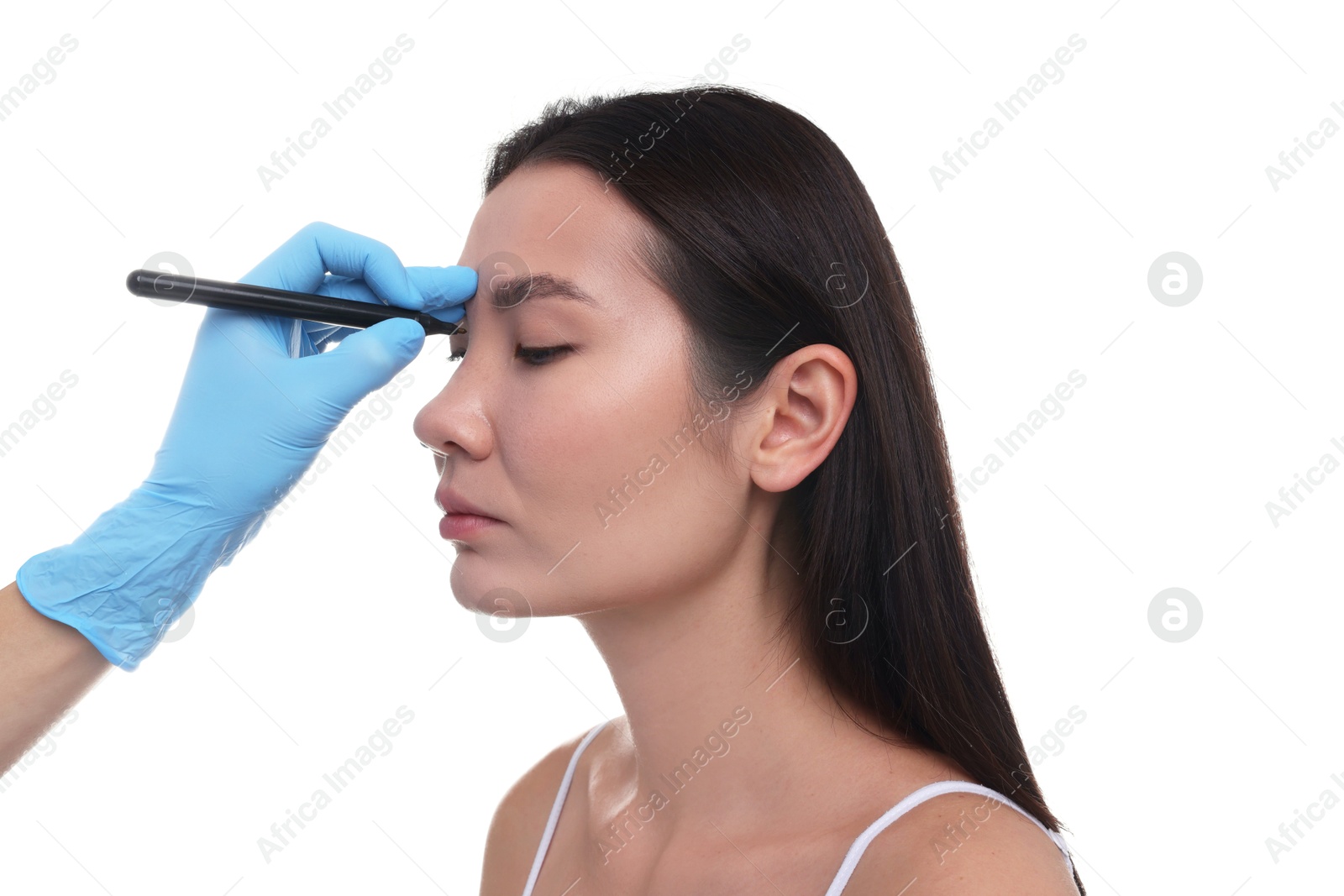 Photo of Doctor drawing marks on patient's nose for plastic surgery operation against white background, closeup