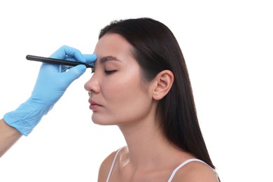 Photo of Doctor drawing marks on patient's nose for plastic surgery operation against white background, closeup