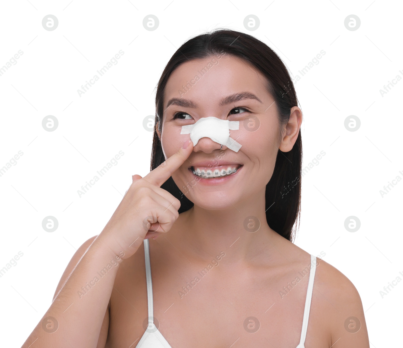 Photo of Woman with medical bandage on her nose after plastic surgery operation against white background