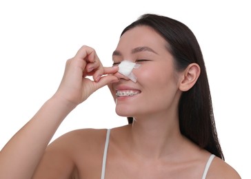 Photo of Woman with medical bandage on her nose after plastic surgery operation against white background