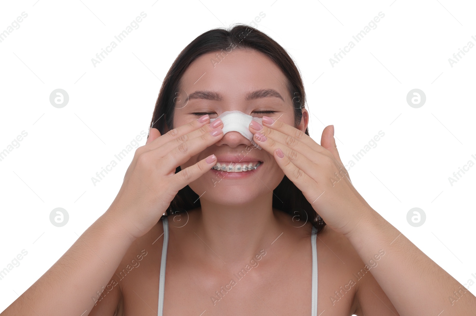 Photo of Woman with medical bandage on her nose after plastic surgery operation against white background