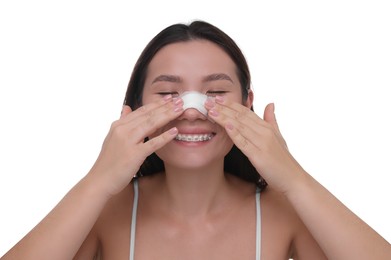 Photo of Woman with medical bandage on her nose after plastic surgery operation against white background