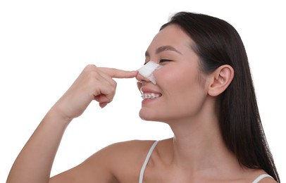 Photo of Woman with medical bandage on her nose after plastic surgery operation against white background