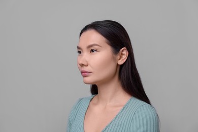 Photo of Woman with beautiful nose on light grey background. Rhinoplasty surgery