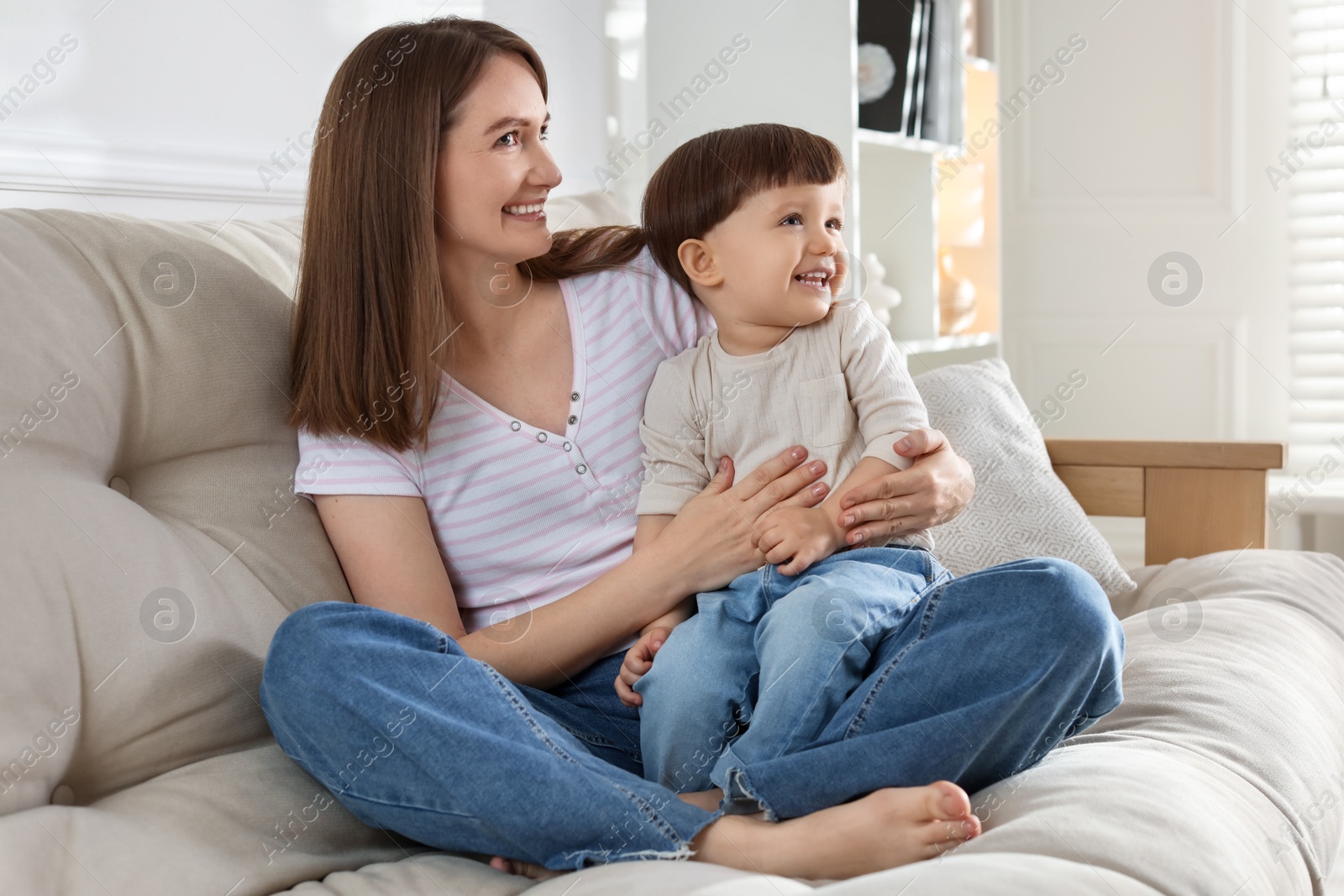 Photo of Happy mother with her cute little son on sofa at home