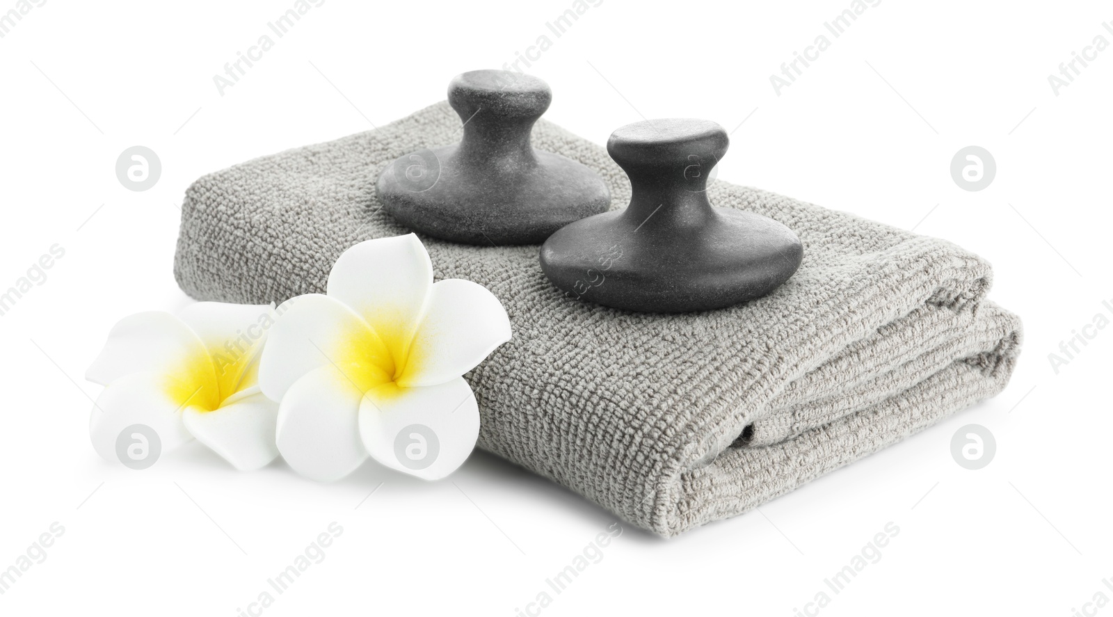 Photo of Spa stones, towel and plumeria flowers isolated on white