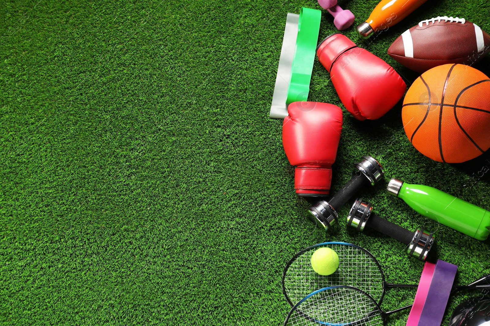 Photo of Different sports equipment on artificial grass, flat lay. Space for text