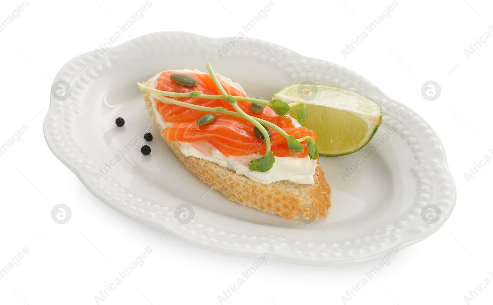 Photo of Delicious bruschetta with cream cheese, salmon and piece of lime isolated on white