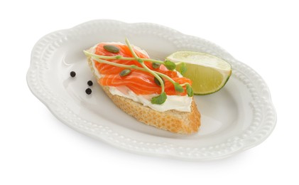 Photo of Delicious bruschetta with cream cheese, salmon and piece of lime isolated on white