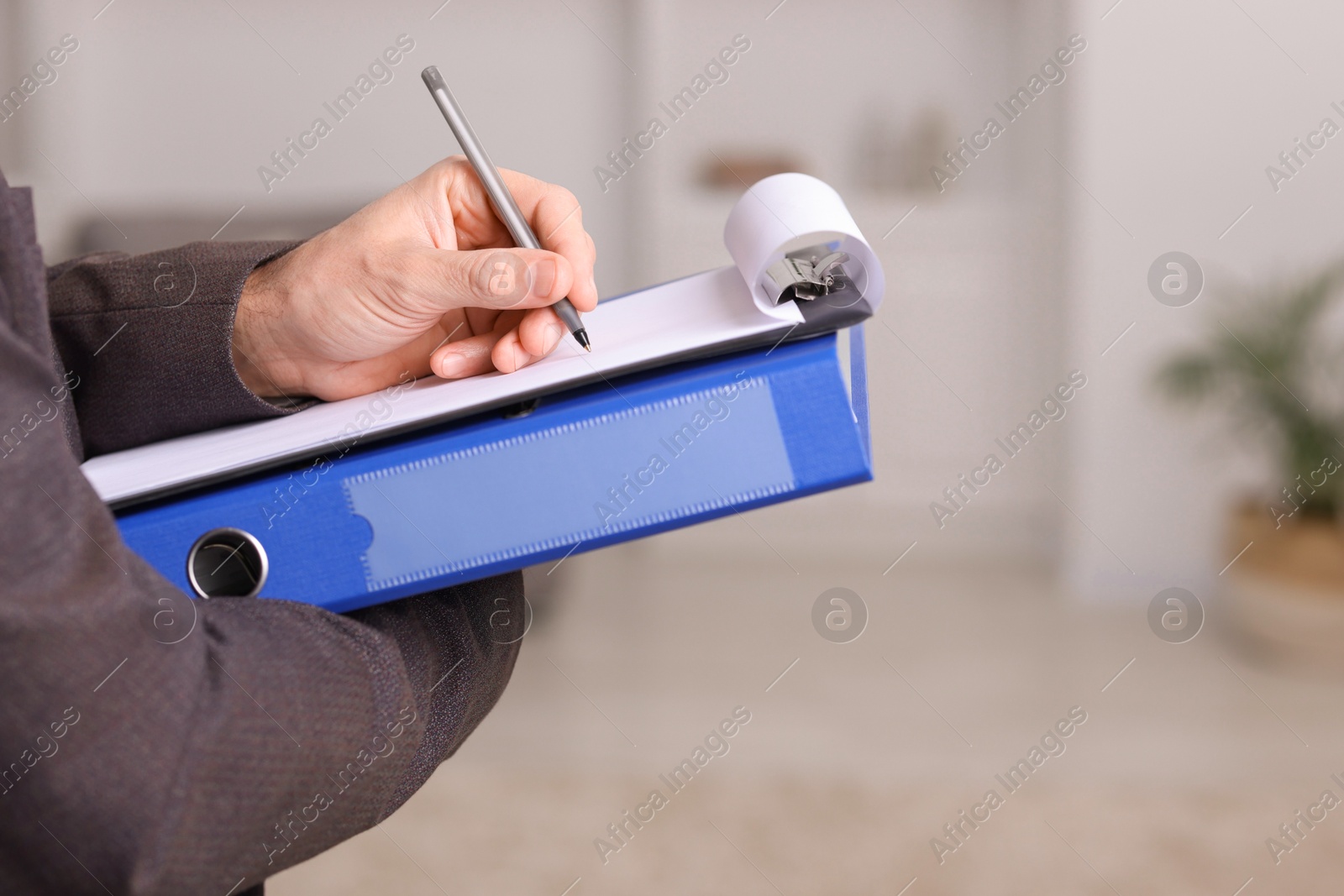 Photo of Real estate appraisal. Inspector with clipboard conducting property valuation indoors, closeup. Space for text