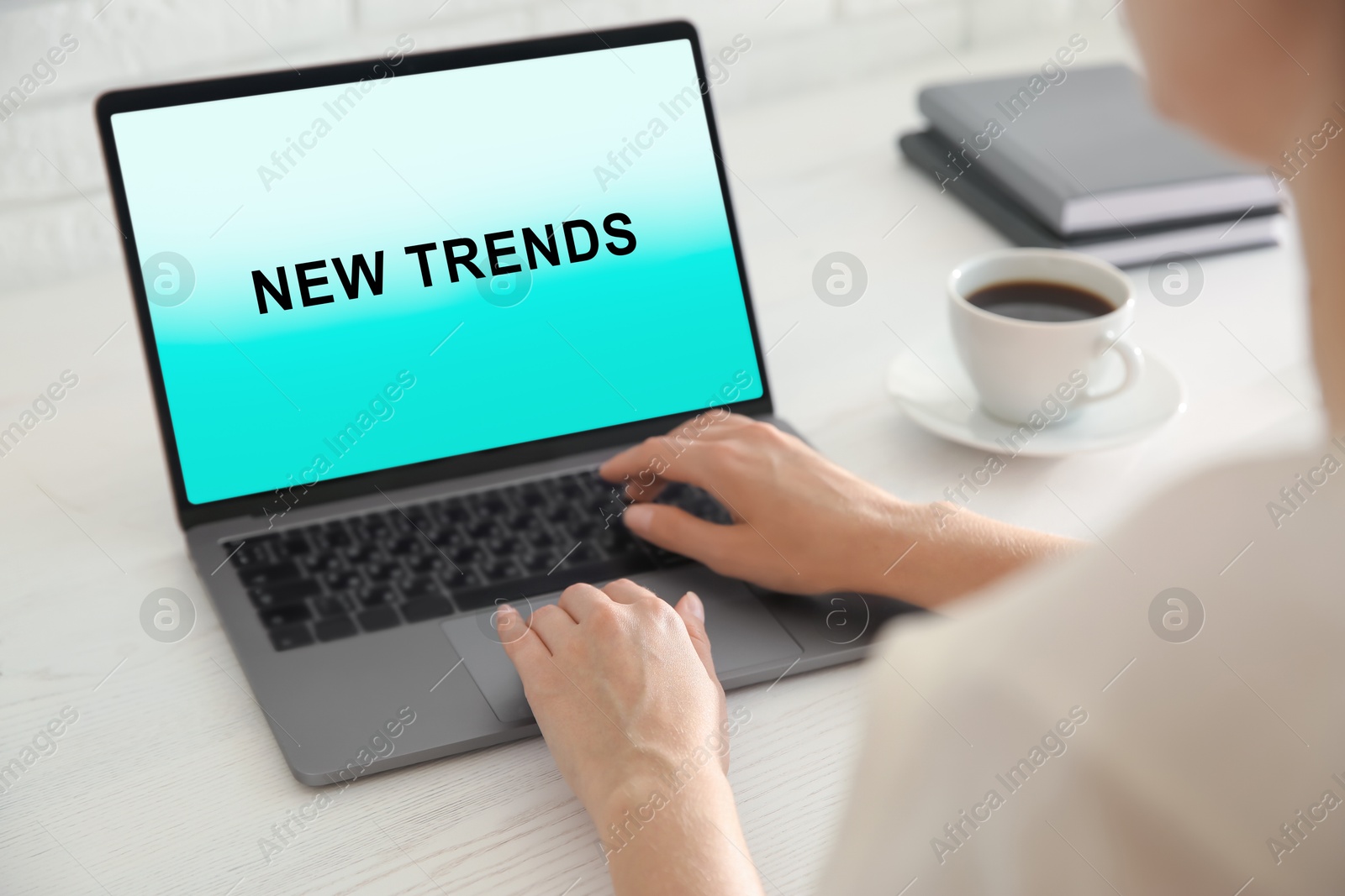 Image of New trends. Woman using modern laptop at white wooden table, closeup