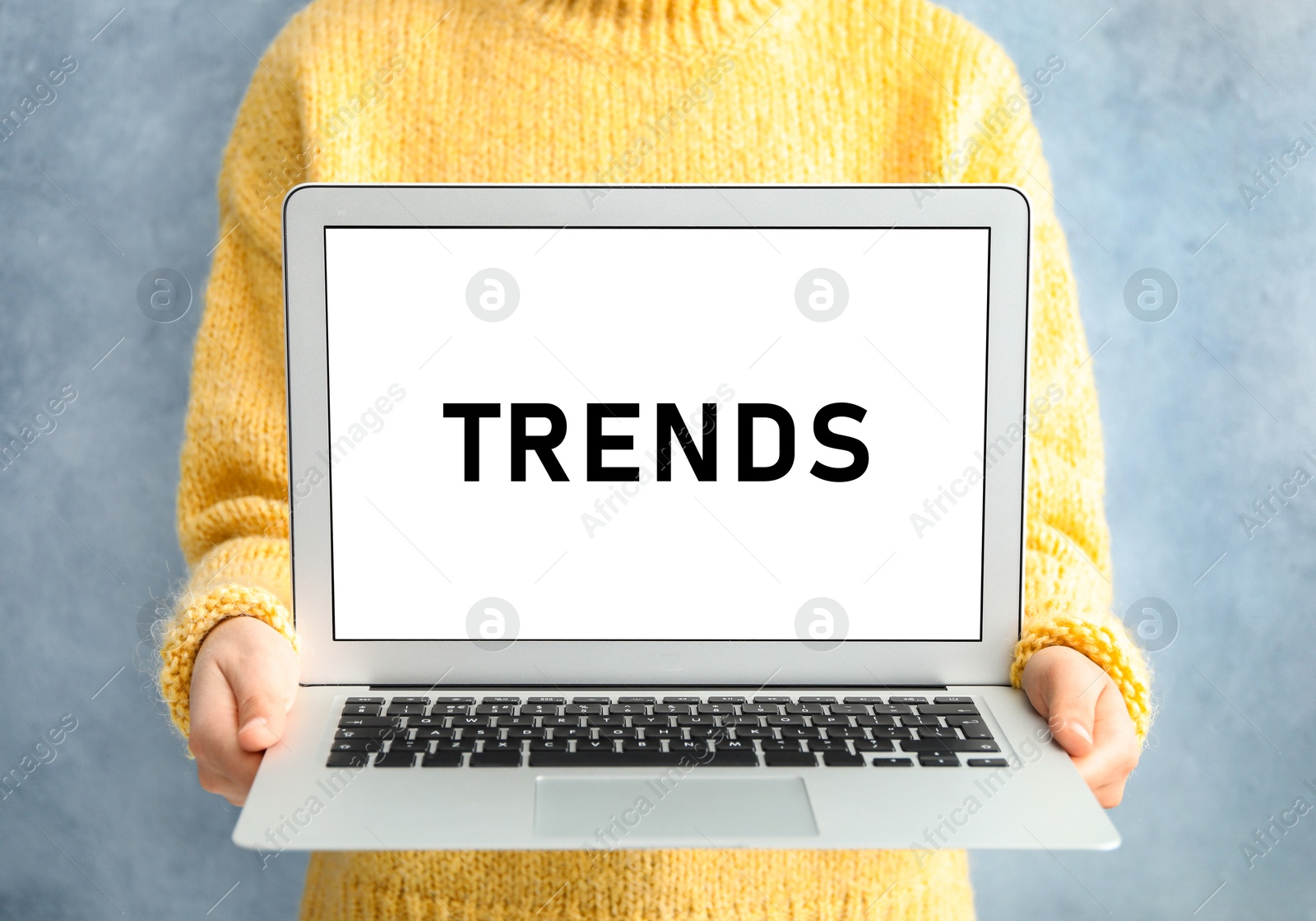 Image of New trends. Woman holding laptop on light blue background, closeup