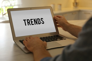 Image of New Trends. Man using laptop at table indoors, closeup