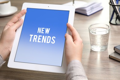 Image of New trends. Woman using modern tablet at table in office, closeup