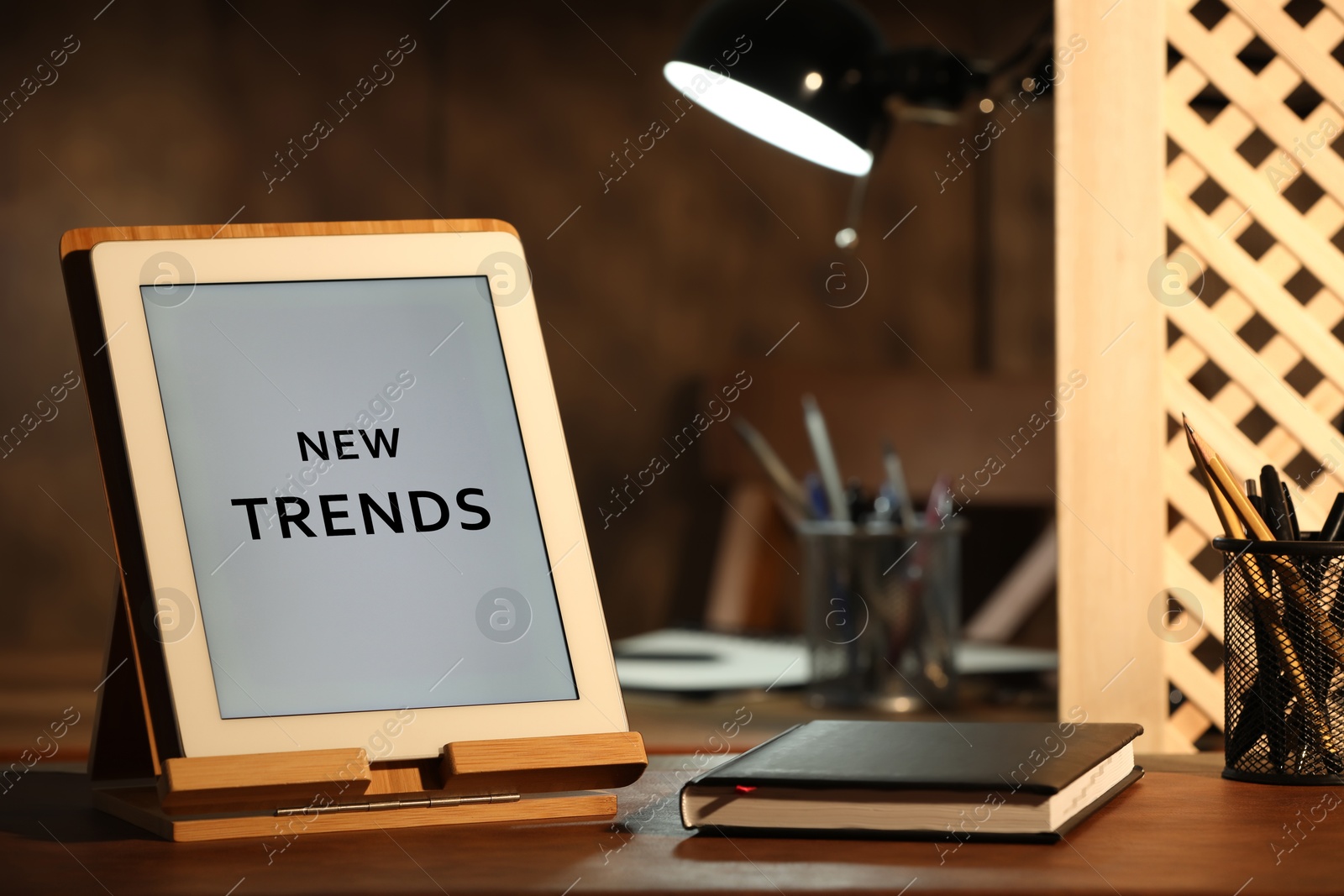 Image of New trends. Modern tablet and planner on wooden table indoors